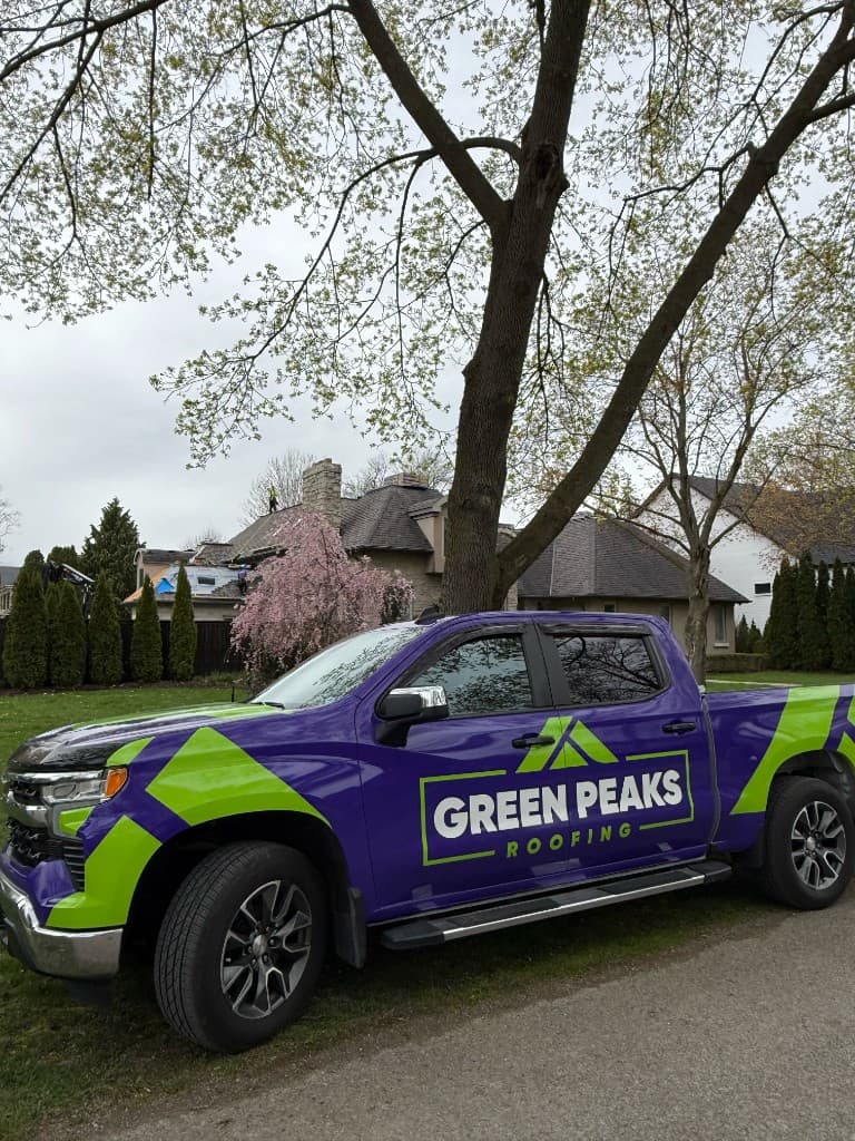 Green Peaks Roofing branded crew truck on-site at a residential roofing project